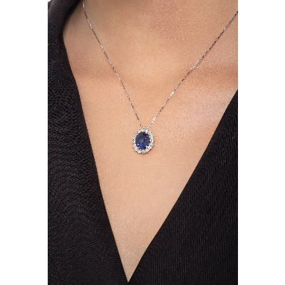 Pendentif en or blanc 18 ct avec saphir bleu taille ovale et halo diamants