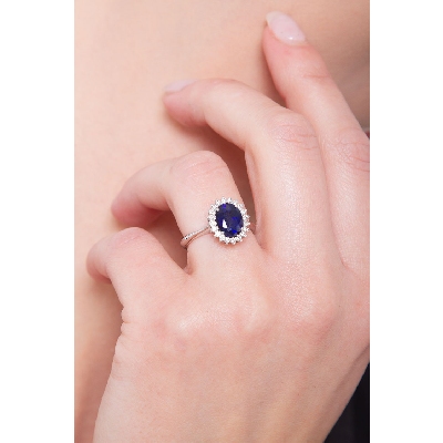 Bague en or blanc avec saphir bleu ovale et halo de diamants