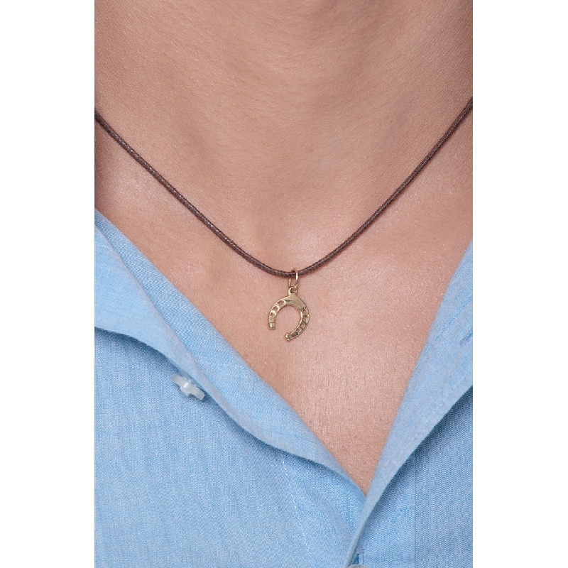 Pendentif fer à cheval en or jaune 18 carats.